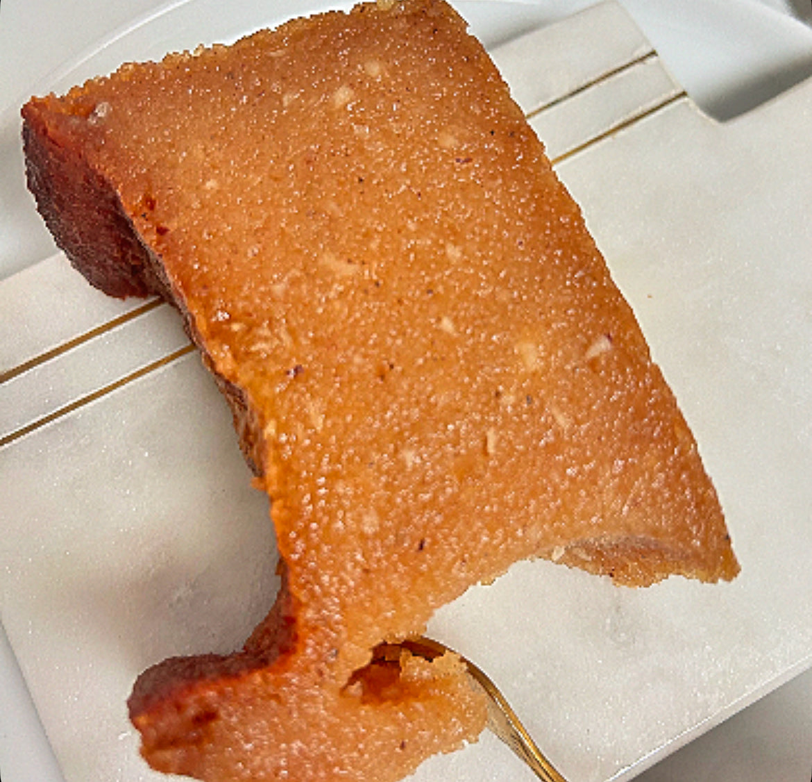 NutmegSpiced homemade sweet potato pudding slice with a bite taken