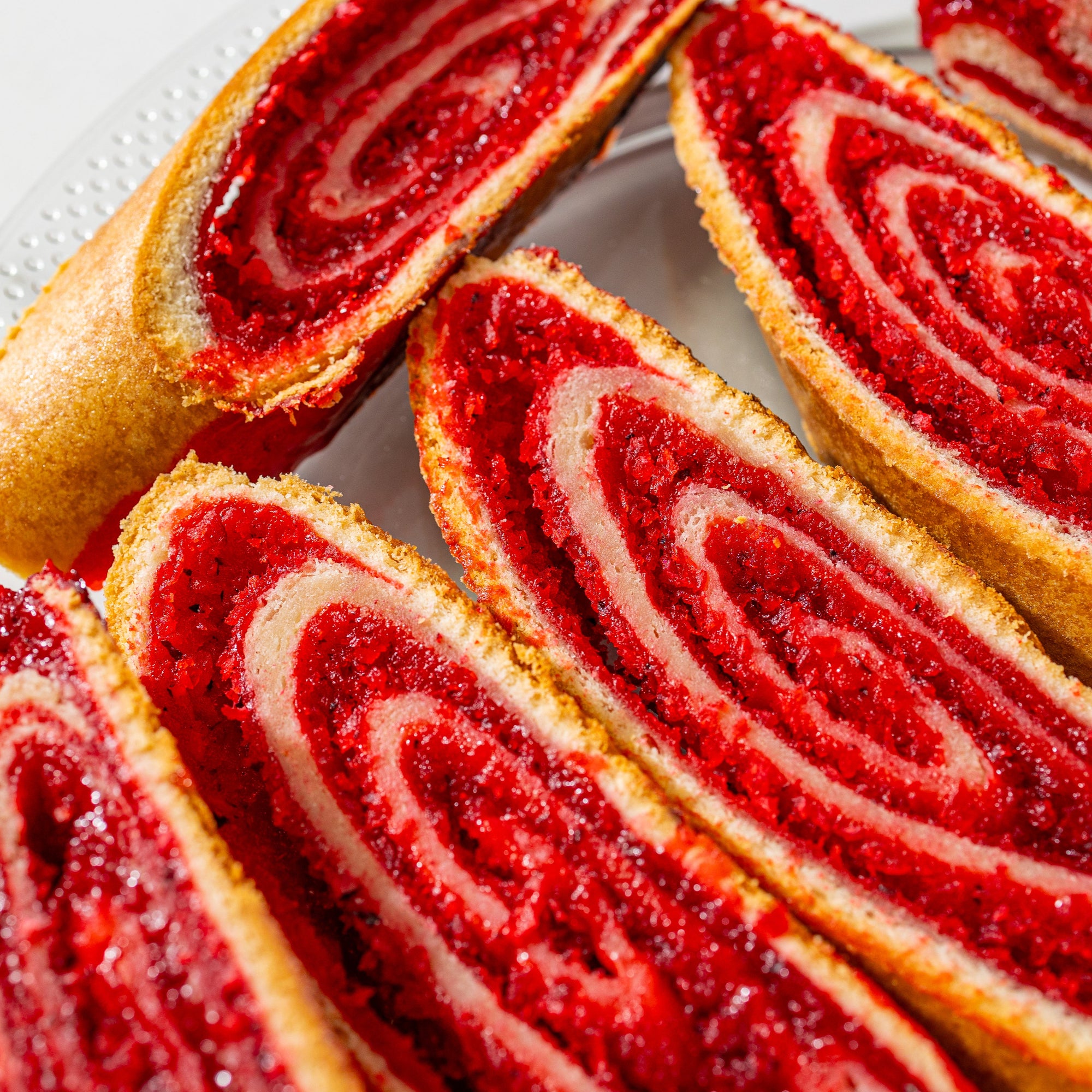 Close-up image of a Grenadian Cut-Cake with visible layers of red coconut red filling,  a tropical dessert.