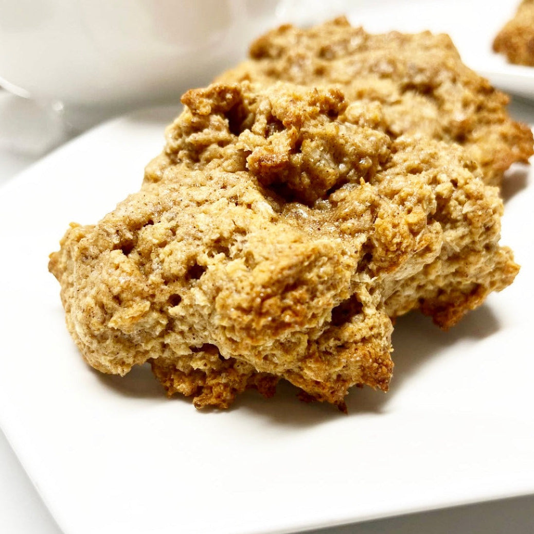 A photo of freshly baked Grenadian coconut drops on a white plate, showing a crispy top and soft texture.